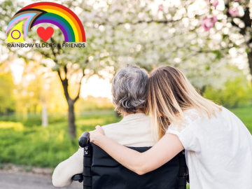 Photo of a person in a wheelchair looking at a garden and a young person next them giving them a hug
